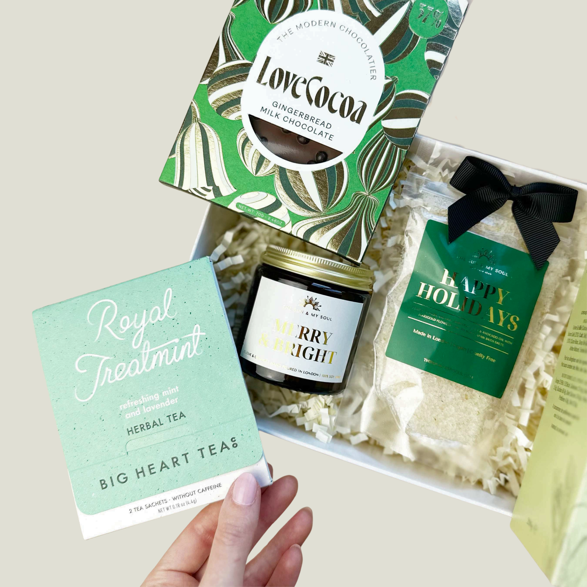 Festive Gift box with tea, chocolate, and bath product on a light background
