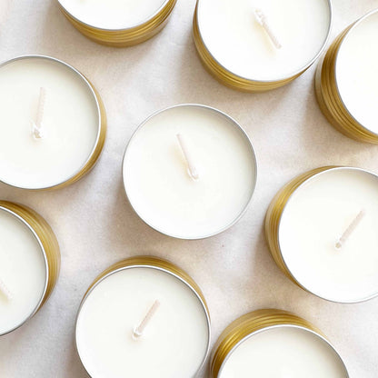 White candles with gold holders arranged on a light background