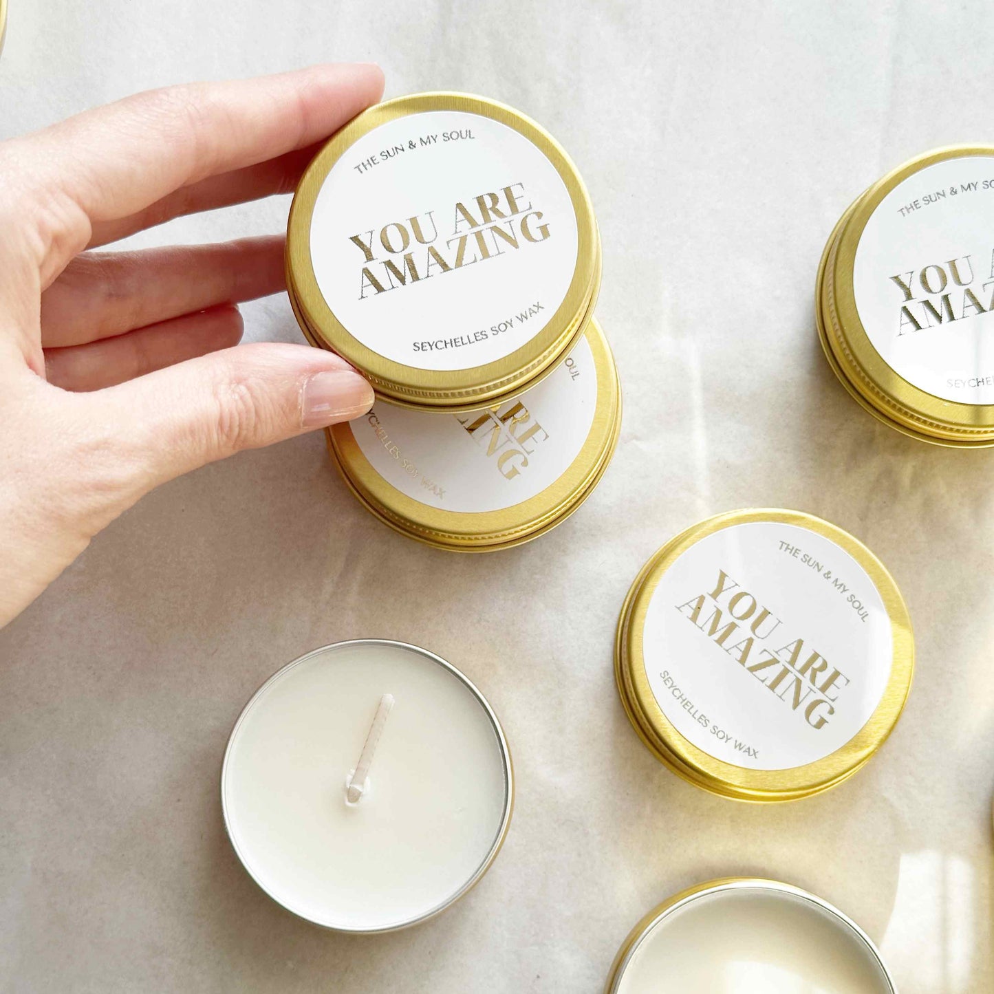 Candle with 'You Are Amazing' lid on a marble surface