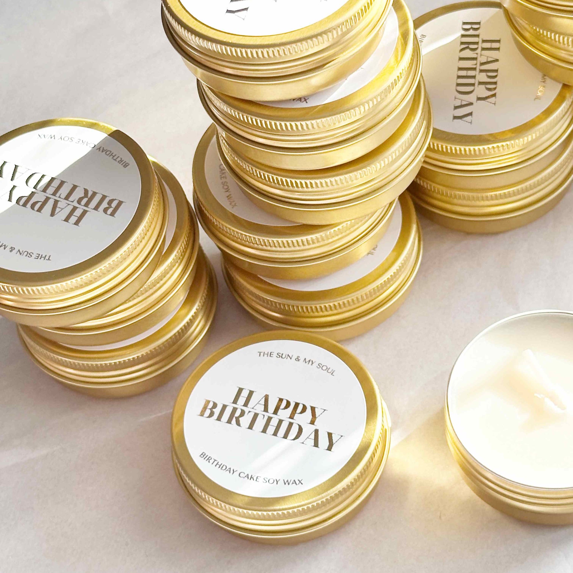 Gold candles with 'Happy Birthday' labels on a light background