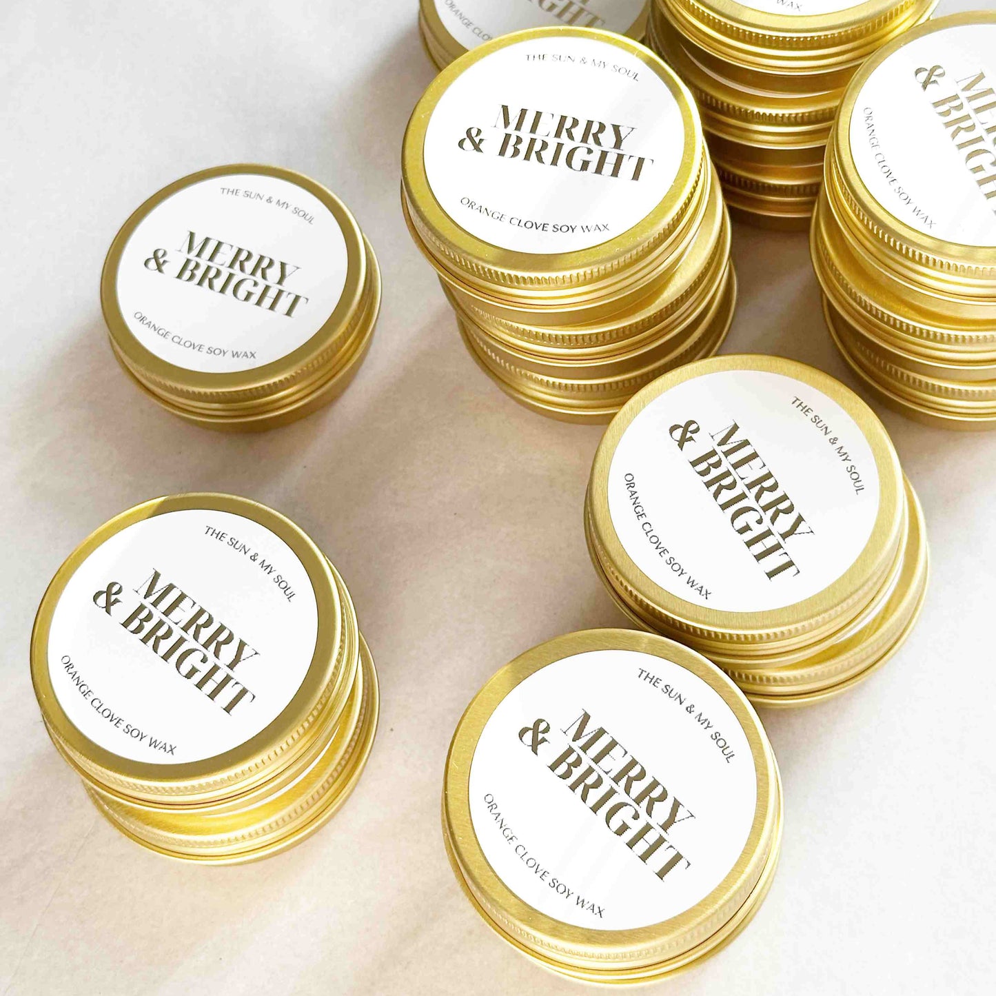 Gold tins with 'Merry & Bright' labels on a light background