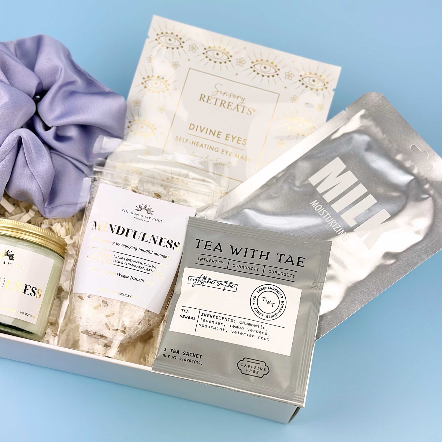 Gift set with tea, eye masks, and a candle on a blue background