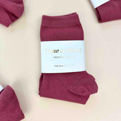 Maroon socks with a label on a beige background