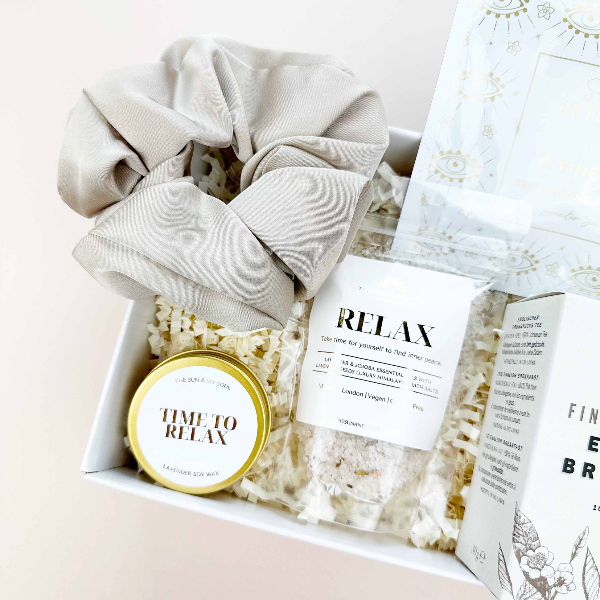 Gift set with scrunchies, popcorn, and a 'Time to Relax' candle on a light background