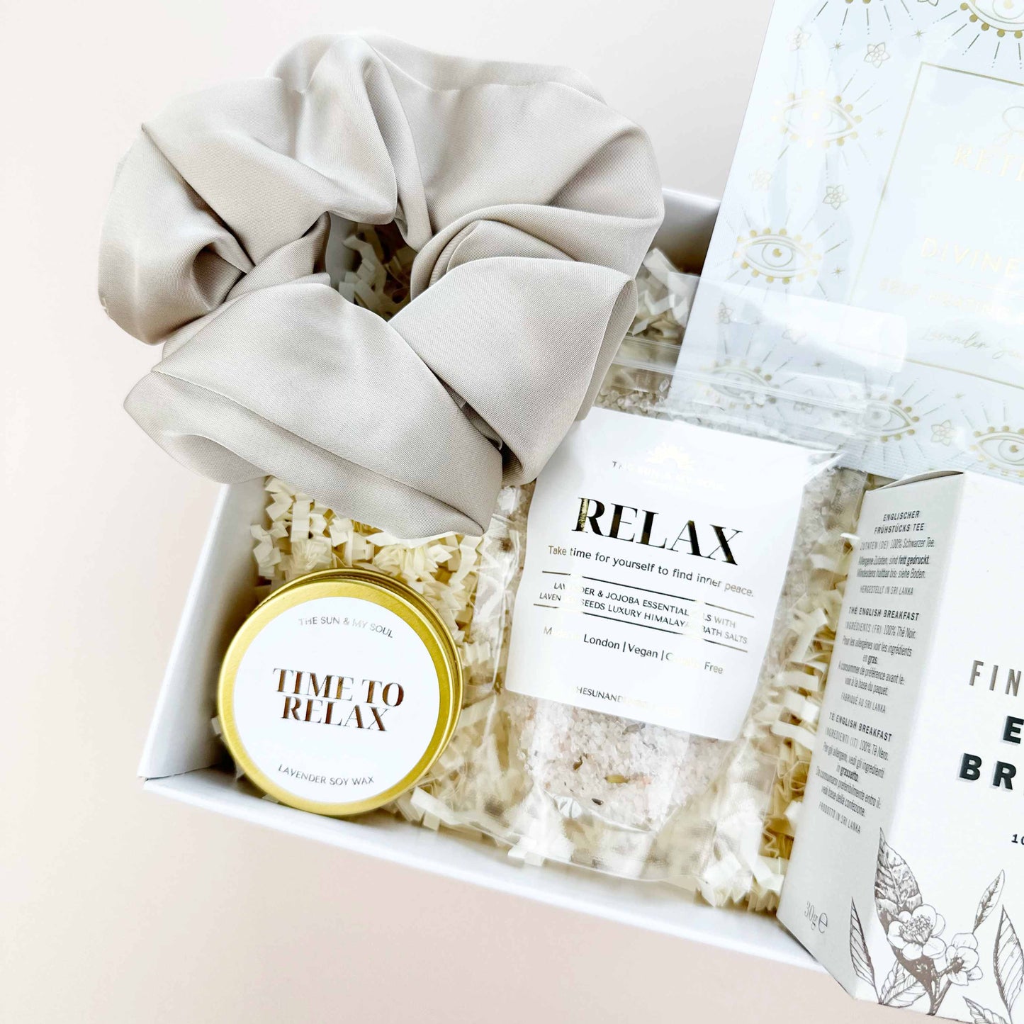 Gift set with scrunchies, popcorn, and a 'Time to Relax' candle on a light background