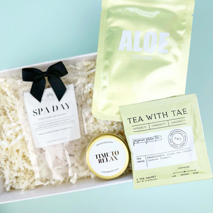 Gift set with aloe vera pouch, tea bag, and other items on a light blue background