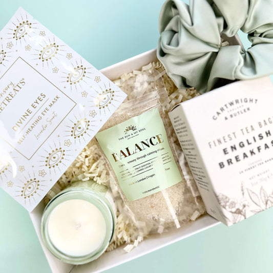 Gift set with a candle, soap, and scrunchie on a light blue background