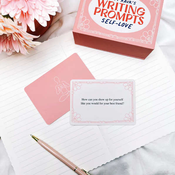 Writing prompts self-love card set with a pen and flowers on a marble surface