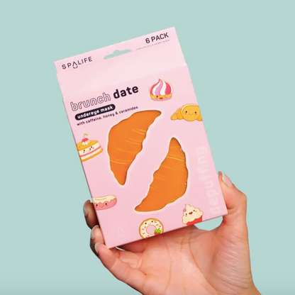 Hand holding a pink package labeled 'brunch date' with cartoon food illustrations on a light blue background.