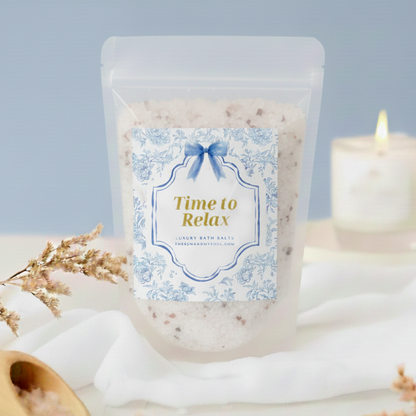 Packaged bath salts with a label reading 'Time to Relax' on a decorative setting with a candle and flowers.
