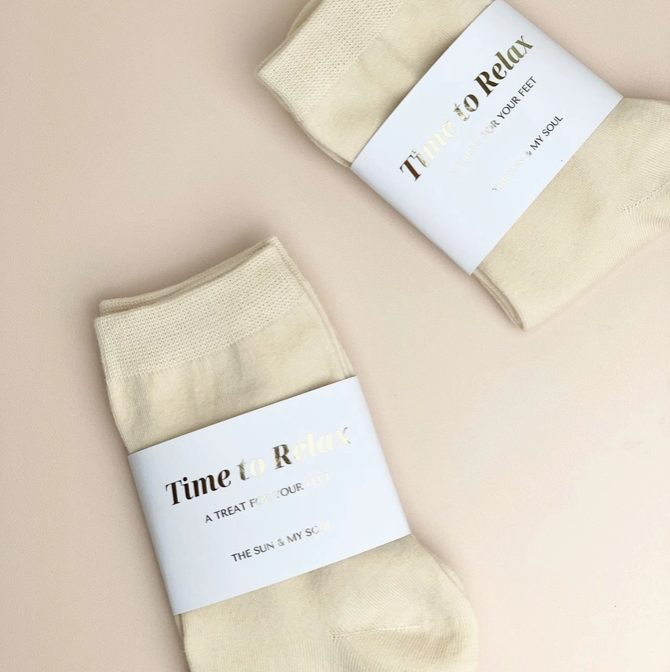 Beige socks with 'Time to Relax' labels on a beige background