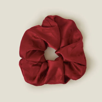 Red scrunchie on a beige background
