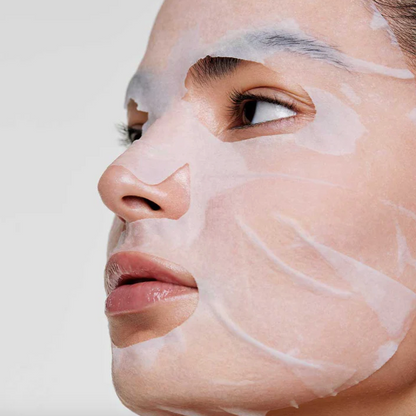 Close-up of a person's face with a white facial mask applied to the skin.